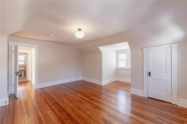 bonus room with wood-type flooring and vaulted ceiling