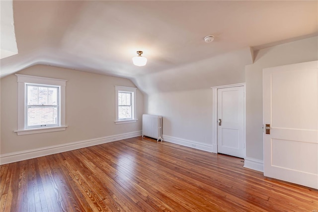 bonus room featuring vaulted ceiling, wood-type flooring, and radiator heating unit