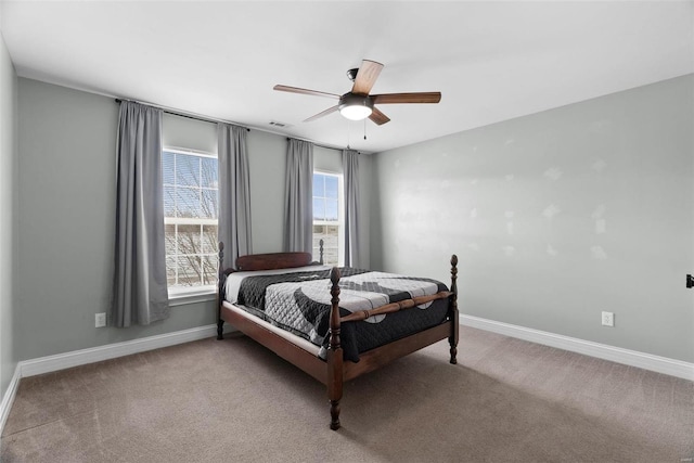 carpeted bedroom featuring visible vents, baseboards, and ceiling fan