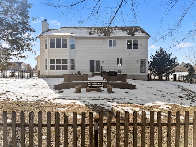 view of snow covered back of property