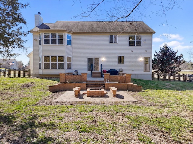 back of house with an outdoor fire pit, a lawn, fence, and a chimney