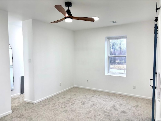 carpeted spare room featuring ceiling fan