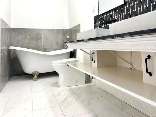 bathroom with toilet, sink, and a tub to relax in