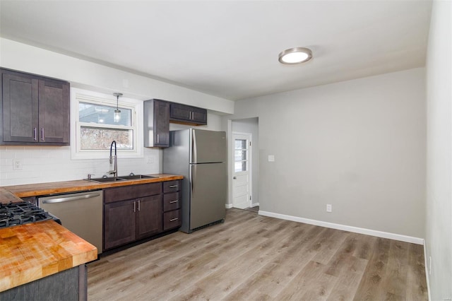 kitchen featuring sink, stainless steel appliances, wooden counters, and dark brown cabinets