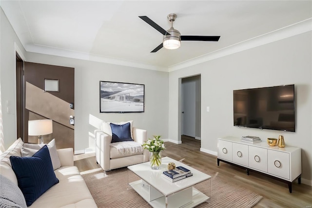 living room with wood-type flooring, ceiling fan, and ornamental molding