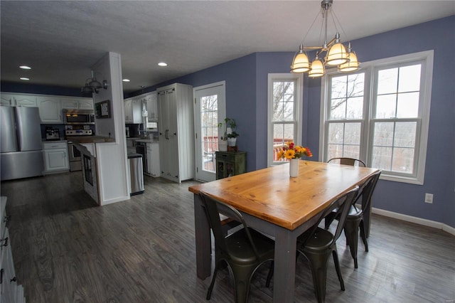 dining area with dark wood-type flooring and a chandelier