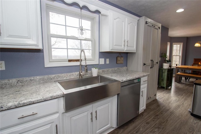 kitchen with dark wood-type flooring, sink, white cabinetry, stainless steel dishwasher, and pendant lighting