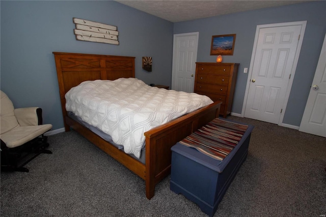 bedroom with dark carpet and a textured ceiling