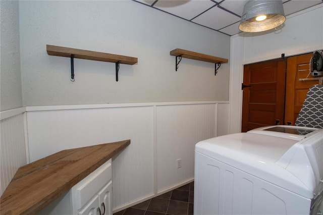 laundry area with cabinets, separate washer and dryer, dark tile patterned floors, and a barn door