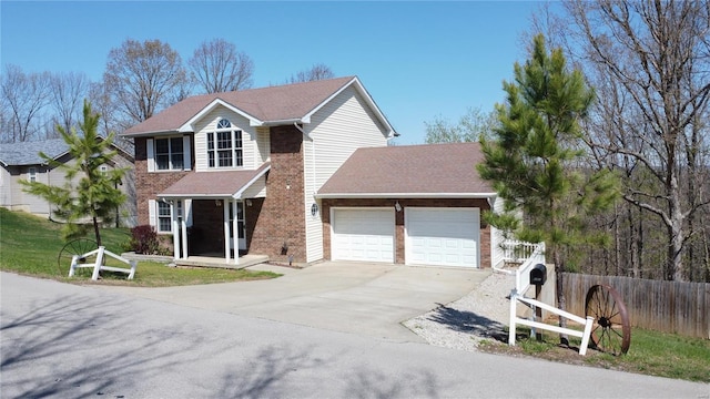 traditional-style home featuring driveway, a garage, fence, and brick siding