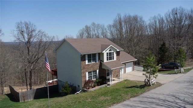 view of front facade with a garage, driveway, fence, and a front lawn