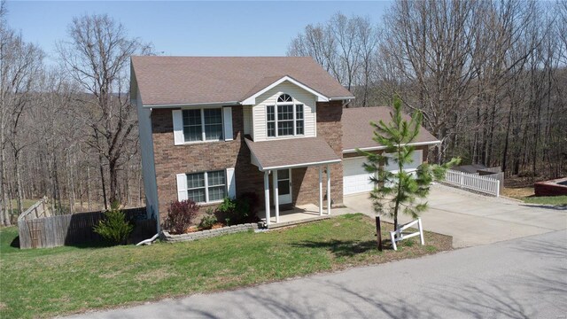 view of front of property featuring a front yard, a shingled roof, an attached garage, fence, and concrete driveway