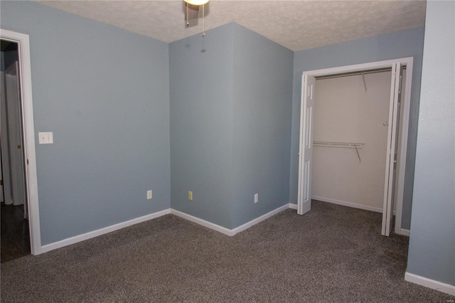 unfurnished bedroom featuring a closet, dark colored carpet, and a textured ceiling
