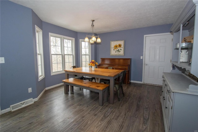 dining area featuring an inviting chandelier, baseboards, dark wood-style floors, and visible vents