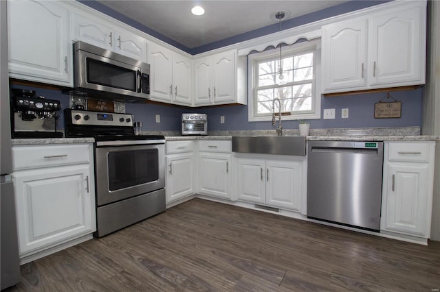 kitchen featuring dark wood-style flooring, white cabinetry, a sink, and appliances with stainless steel finishes