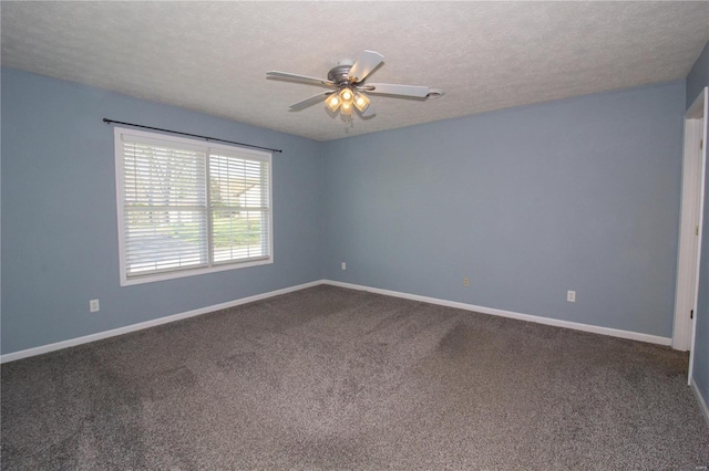 carpeted spare room with a textured ceiling, baseboards, and a ceiling fan