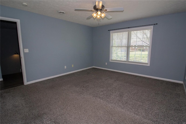 empty room with dark colored carpet, visible vents, baseboards, and ceiling fan