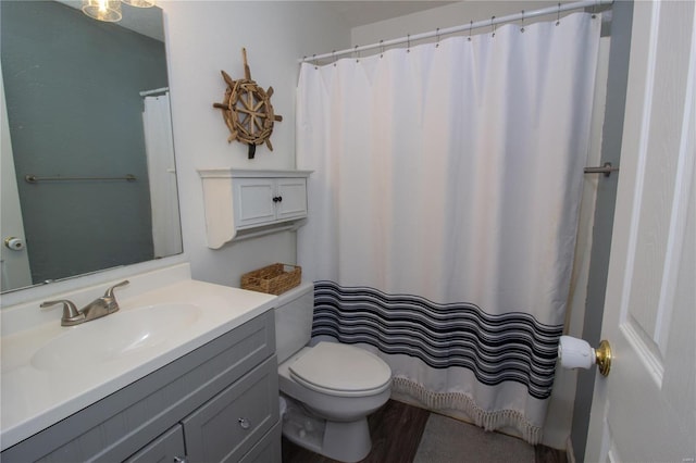 bathroom with a shower with shower curtain, vanity, toilet, and wood finished floors