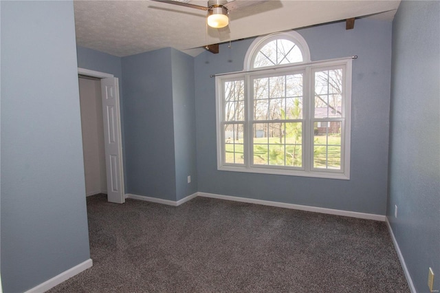 carpeted spare room with baseboards and a ceiling fan