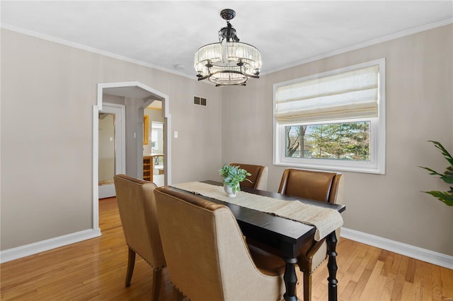 dining room featuring a notable chandelier, crown molding, and light hardwood / wood-style floors