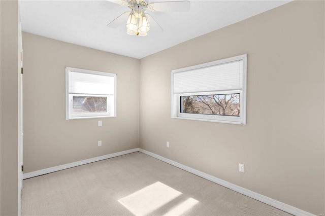 unfurnished room with a wealth of natural light, light colored carpet, and ceiling fan