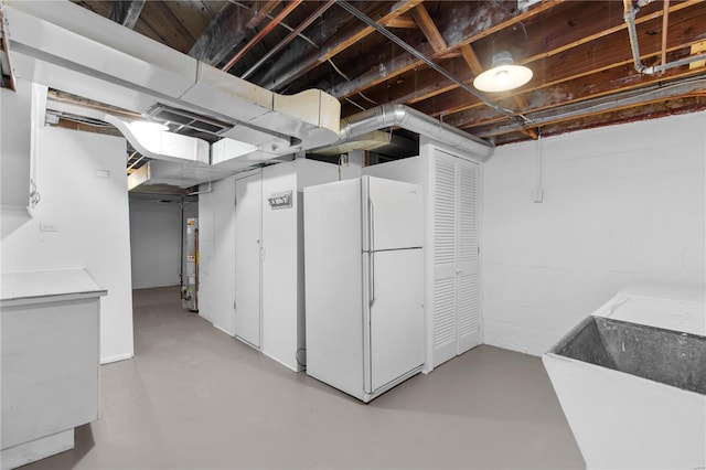 basement with gas water heater, white fridge, and sink