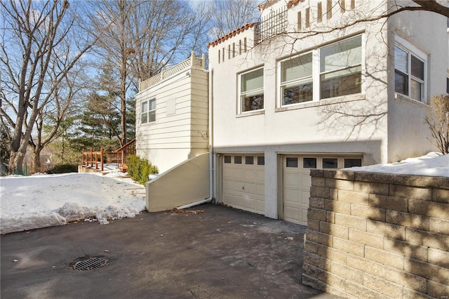 view of snow covered exterior with a garage