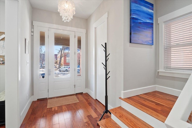 foyer entrance with a notable chandelier and hardwood / wood-style flooring