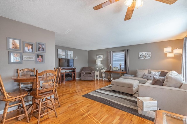 living room with hardwood / wood-style flooring, a textured ceiling, and ceiling fan