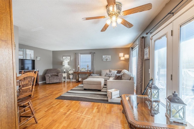 living room with hardwood / wood-style flooring, a textured ceiling, a healthy amount of sunlight, and ceiling fan