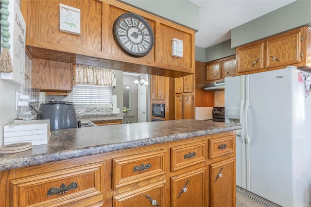 kitchen featuring white fridge with ice dispenser, black microwave, and a chandelier