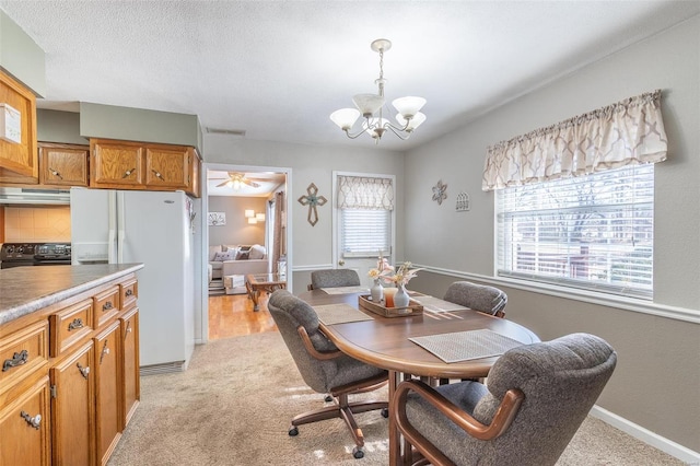 dining space featuring light colored carpet, an inviting chandelier, and plenty of natural light