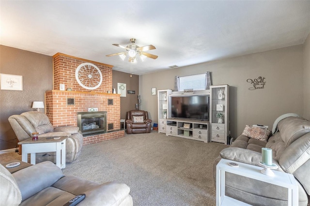 carpeted living room with a fireplace and ceiling fan