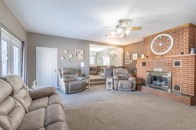 carpeted living room with ceiling fan with notable chandelier and a fireplace