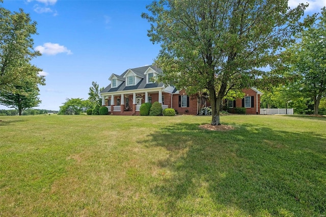 cape cod house featuring covered porch and a front lawn