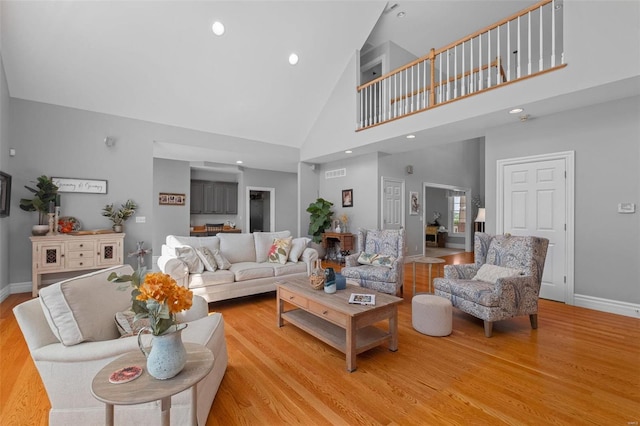 living room with high vaulted ceiling and light hardwood / wood-style floors