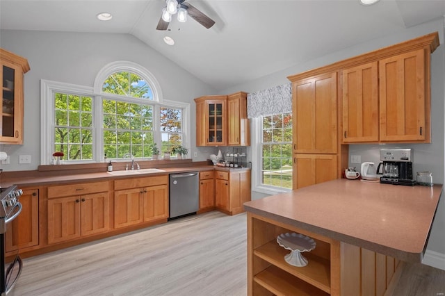 kitchen with ceiling fan, kitchen peninsula, sink, light hardwood / wood-style flooring, and stainless steel appliances