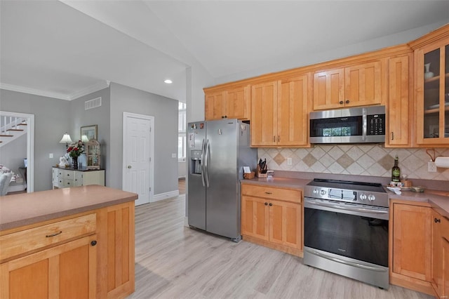 kitchen with appliances with stainless steel finishes, decorative backsplash, light wood-type flooring, lofted ceiling, and ornamental molding