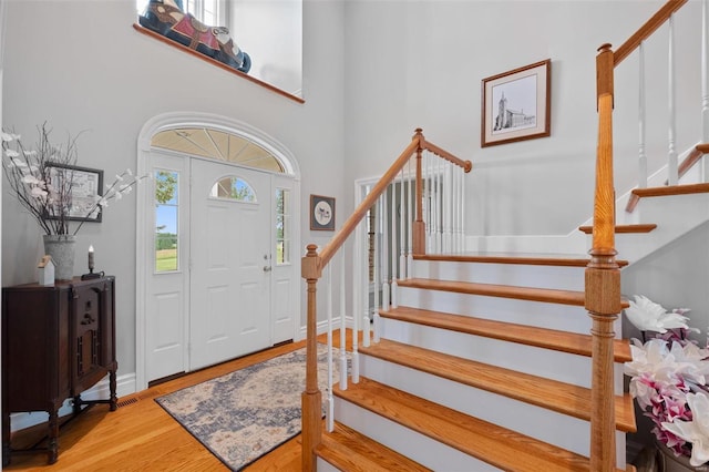 foyer entrance with a high ceiling and light wood-type flooring