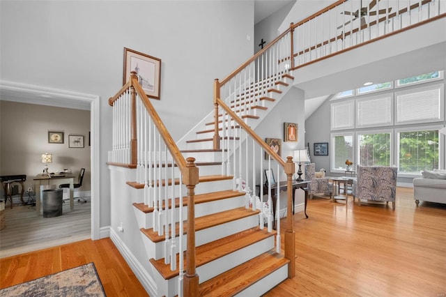 stairway featuring hardwood / wood-style flooring and a towering ceiling