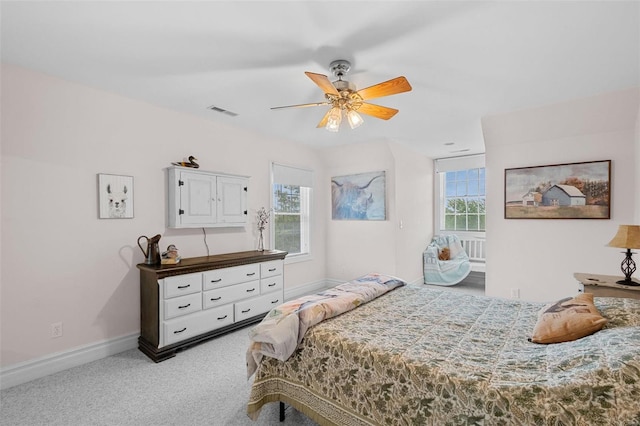 bedroom featuring ceiling fan, multiple windows, and carpet