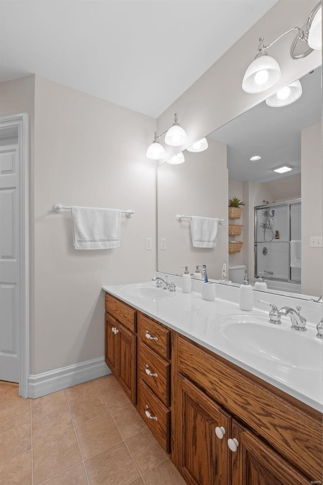 bathroom with toilet, vanity, and tile patterned floors