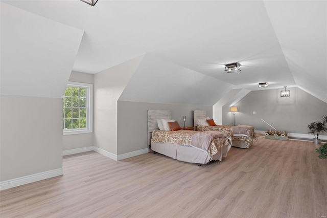 bedroom featuring lofted ceiling and light wood-type flooring