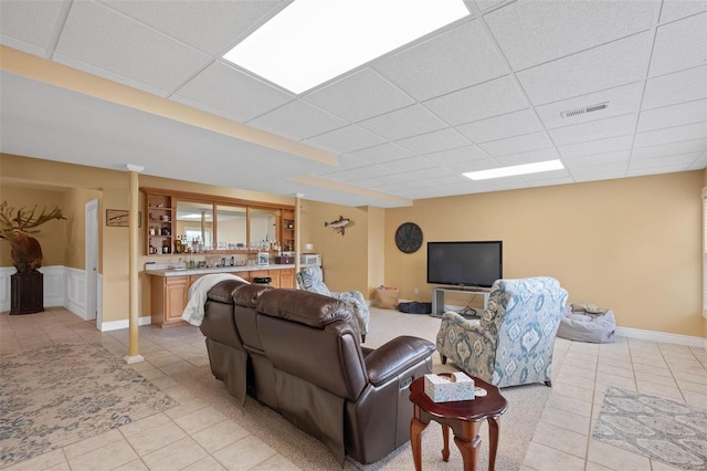 tiled living room with a drop ceiling