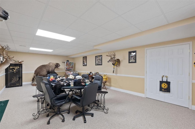 carpeted dining space with a drop ceiling