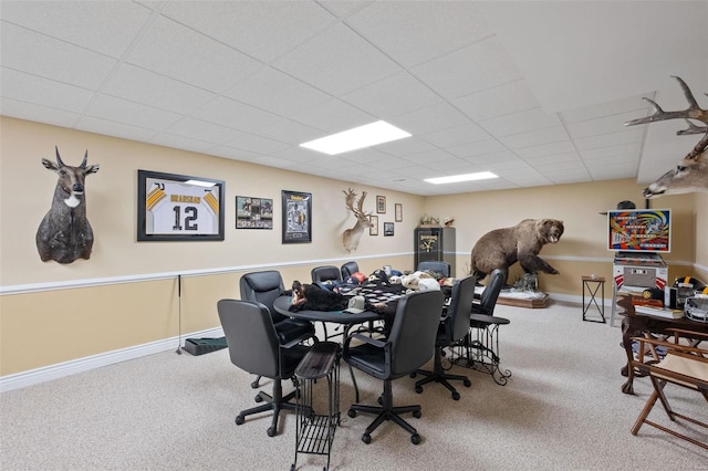 carpeted office space with a paneled ceiling