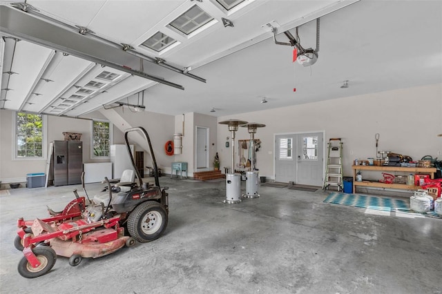 garage featuring stainless steel refrigerator with ice dispenser and a garage door opener