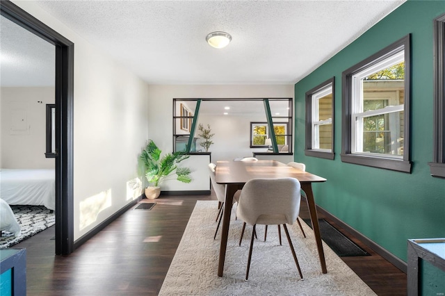 dining room featuring dark hardwood / wood-style flooring and a textured ceiling