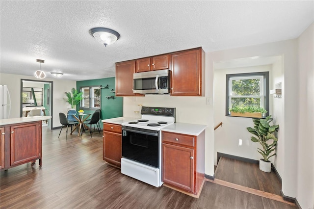 kitchen with a textured ceiling, dark hardwood / wood-style flooring, and white appliances