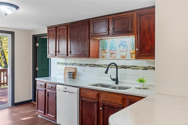 kitchen featuring a textured ceiling, dishwasher, wood-type flooring, sink, and backsplash